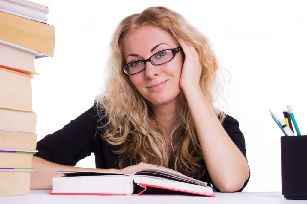 Elementary student smiling with a stack of books